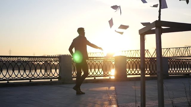 A man throws important documents and goes into the sunset. HD, 1920x1080, slow motion