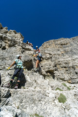 Fototapeta na wymiar mountain guide and several clients climbing a Via Ferrata in the Italaian Dolomites