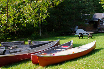 three canoes at on lawn at camp