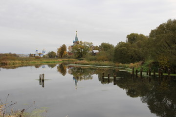 Landscape of Dunilovo village with church  and monastery on the river in cloudy fall day