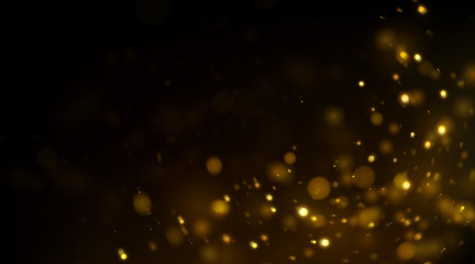Fototapeta na wymiar Glowing golden particles on black background