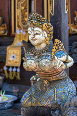Fototapeta premium Traditional Balinese stone statuette of the deity in the street temple. Island Bali, Indonesia . Closeup