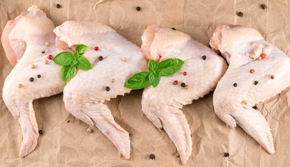 .Raw chicken wings with seasonings on paper