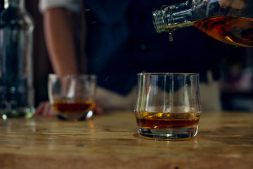 glass of whiskey and cigar on wooden table