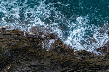 Foamy sea at a rocky shore - natural background