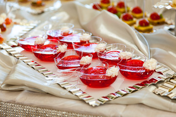 Raspberry Jello with fresh fruits on a festive table close up