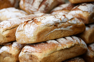 Pile of freshly baked wholemeal breads in the bakery or local farmer market.