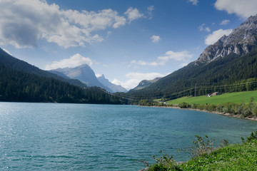 high voltage power lines across a mountain lake reservoir used for generating hydroelectric power