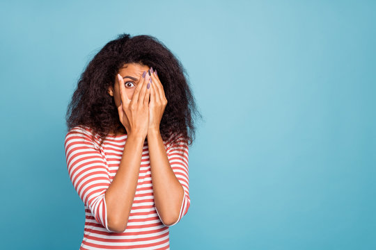 Photo Of Horrified Scared Black Woan Covering Her Face With Hands Hiding From Danger Looking Through Hand Isolated Over Blue Vibrant Color Background