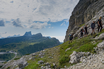 group of mountain climbers hiking up a mountain side to a hard climbing route