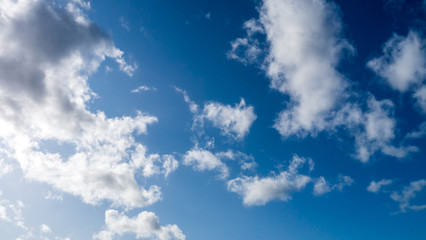 Beautiful deep blue sky with white bright sun filled clouds.
