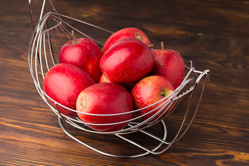 Composition with Red Apples on the dark wooden table, concrete wall background