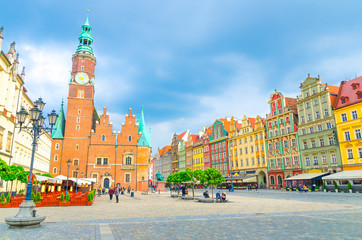 Old Town Hall building, row of colorful buildings with multicolored facade and street lamp on cobblestone Rynek Market Square in old town historical city centre of Wroclaw, Poland