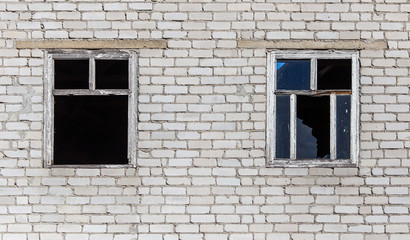 Fototapeta na wymiar Broken windows of a brick house