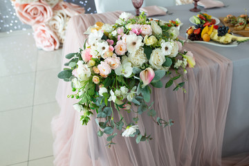 Table decorations made of artificial bouquets of flowers in a vase during catering at a wedding or events.