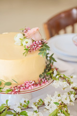 Fototapeta na wymiar Wedding cake with flowers, boho style table setting. Holiday cake on table