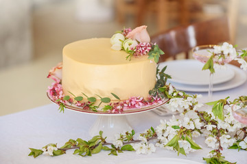 Wedding cake with flowers, boho style table setting. Holiday cake on table