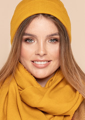 Fashionable smiling girl in autumn yellow cap.