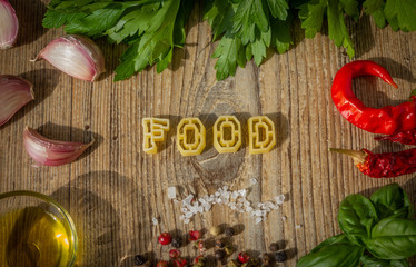lettere di pasta cruda compongono la scritta food su tavolo di legno