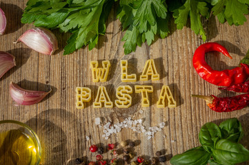 lettere di pasta cruda compongono la scritta food su tavolo di legno