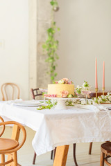 Festive wedding table with cake, champagne, candles and snacks