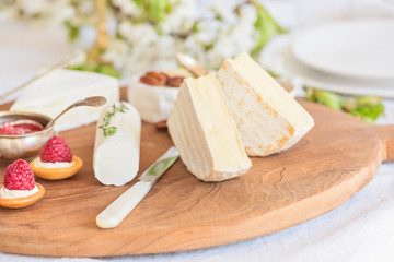Сheese plate, a festive snack of different types of cheeses, honey, nuts and berries