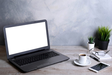 Fototapeta premium Laptop with blank screen for graphic display montage .Computer on wooden gray desk in office room. Mock up with plastic plant