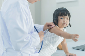 Asian doctor using a stethoscope to check his breathing and heart of a lovely girl, check the health of children,Thailand people
