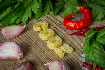 lettere di pasta cruda compongono la scritta food su tavolo di legno