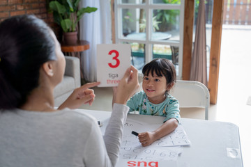 parent showing number on a flash card during studying at home