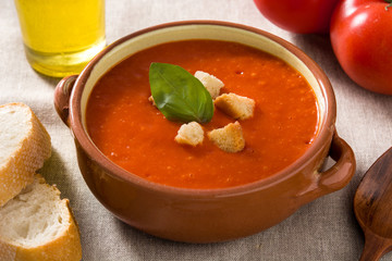 Tomato soup in brown bowl garnished with croutons