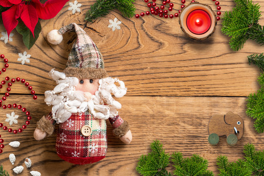 Christmas decoration and Santa Claus rag doll on wooden background 