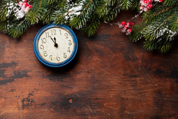 Christmas fir tree and alarm clock over old wood