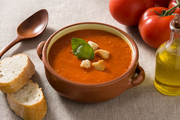 Tomato soup in brown bowl garnished with croutons