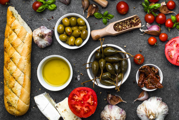 Italian food or mediterranean diet background. Cooking ingredients: herbs, spices, basil, tomato, olive, oil, bread.