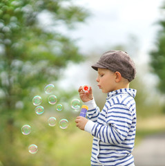 kleiner Junge macht Seifenblasen im Herbst
