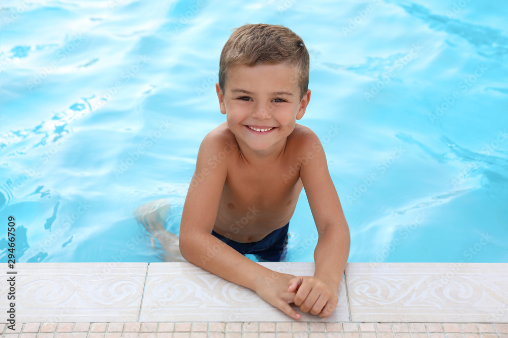 Poster cute little boy in outdoor swimming pool