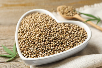 Raw organic hemp seeds on wooden table