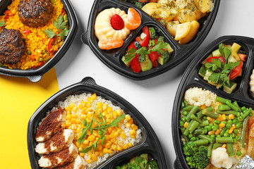 Lunchboxes with different meals on color table, flat lay. Healthy food delivery