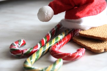 Santa's red hat, three candy canes and two cookies. the concept of Christmas and new year sweets. Christmas dwarf hat