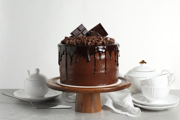 Freshly made delicious chocolate cake on grey table against white background