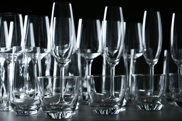 Set of empty glasses on table against black background
