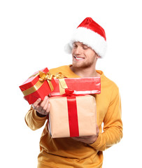 Young man with Christmas gifts on white background