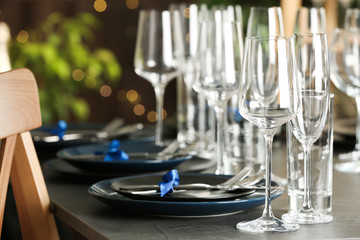 Table setting with empty glasses, plates and cutlery indoors
