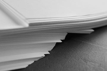 Stack of blank paper on grey stone table, closeup