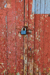 Wooden surface with cracked red paint texture and lock