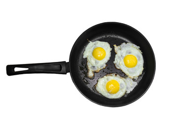 Three fried eggs in a cast iron frying pan isolated on white background. Concept of fast and healthy breakfast, top view