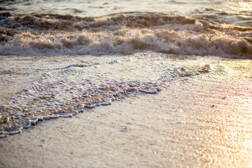 Amazing beach sunset and incredible soft foamy waves. Golden sandy background for romantic text.