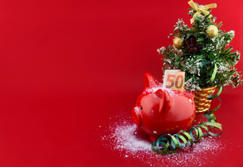 Christmas piggy bank with ribbon on red background