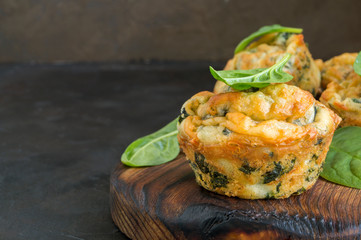 homemade cheese muffins with spinach. on dark background.